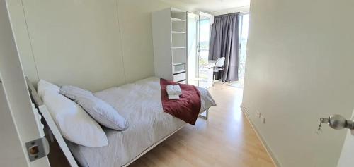 a bedroom with a bed with white sheets and pillows at Dana-Cozy Private Room in Shared Central Apt-Rm 1 in Canberra