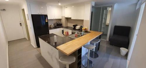 - une cuisine avec un comptoir en bois dans l'établissement Cozy Room in 2-Room Central Apartment-1, à Canberra