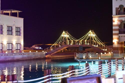 a bridge over the water at night with buildings at Marina Residence Suites Port Ghalib in Port Ghalib