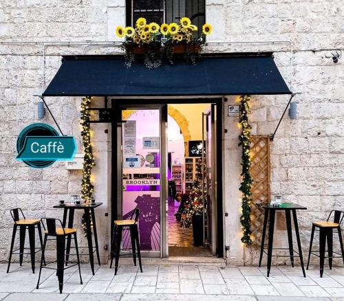 a cafe with tables and chairs in front of a building at CD Romanello (Mura S. Cataldo) in Barletta