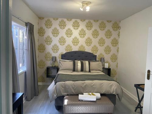 una camera con un letto con una panca di Nonna's Cottage a Durban