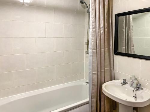 a bathroom with a sink and a tub and a toilet at Sunny Rhyl Apartment - Uk44631 in Rhyl