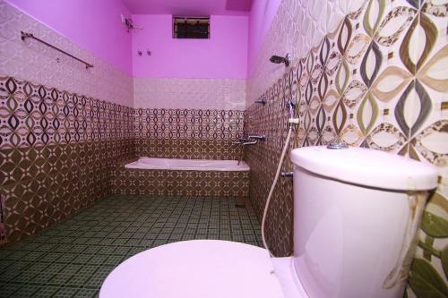 a bathroom with a toilet and a bath tub at Mount view Holidays in Vagamon