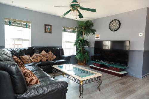 a living room with a black leather couch and a coffee table at AMAZING!!!! Luxury 5BR, Steps to beach and Fun! Fully Renovated Beach house! in Atlantic City