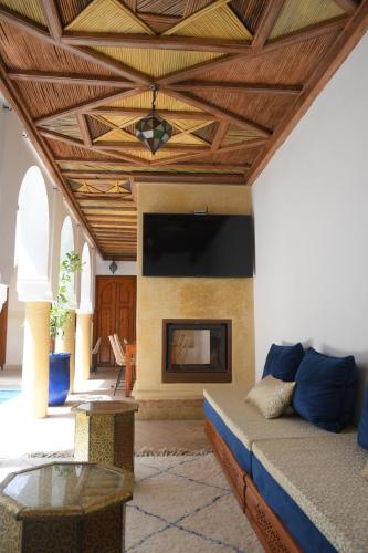 a living room with a couch and a fireplace at Riad Berenssi in Marrakech