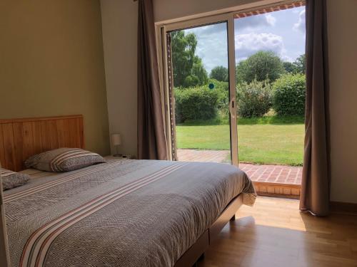 1 dormitorio con cama y ventana grande en Gite Ô pré, en Beaubec-la-Rosière