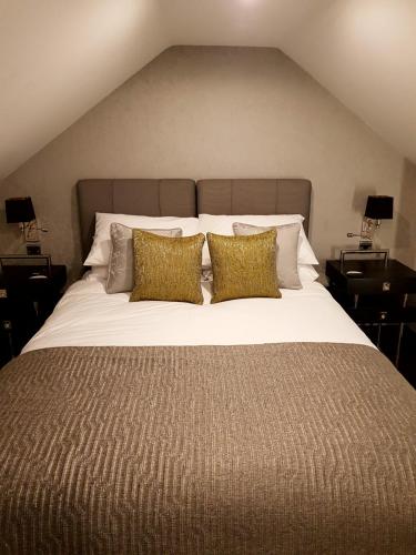 a bedroom with a large bed with two pillows at The Queens Head, Parkside Apartment 1 in Burley in Wharfedale