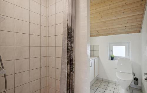 a bathroom with a toilet and a wooden ceiling at Nice Home In Vinderup With Sauna in Vinderup
