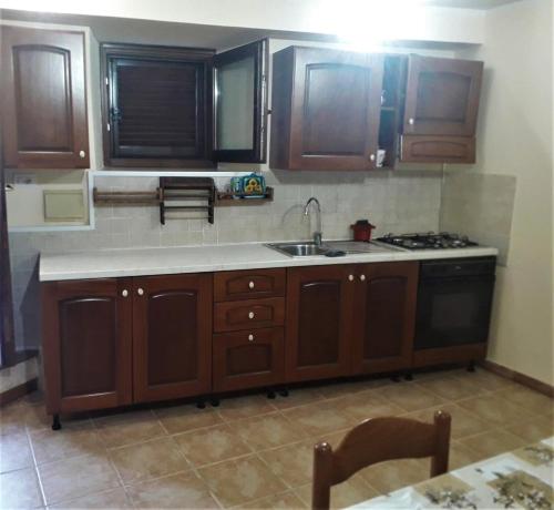 a kitchen with wooden cabinets and a sink and a stove at Casetta Santa Maria in Subiaco