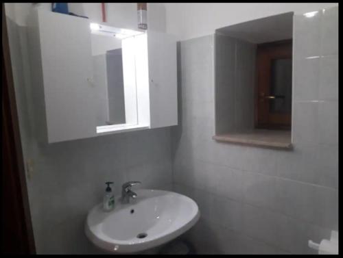 a white bathroom with a sink and a mirror at Casetta Santa Maria in Subiaco