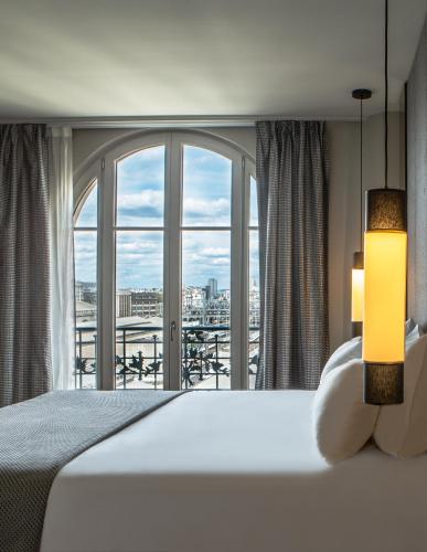 une chambre avec un lit et une grande fenêtre dans l'établissement Hotel Flanelles Paris, à Paris