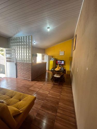 a living room with a couch and a table at AMPLO SOBRADO BEM NO CENTRO, faça tudo a PÉ! in São Bento do Sapucaí