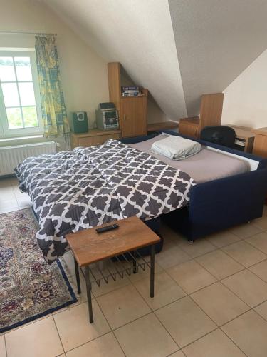 ein Schlafzimmer mit einem Bett mit einer schwarzen und weißen Decke in der Unterkunft Appartement Huldange in Huldange