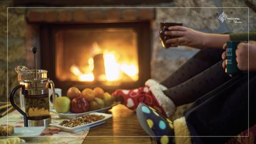 a person sitting in front of a fireplace holding a drink at Εσπερίδες in Naousa Imathias