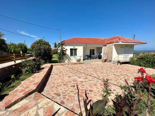 a house with a brick patio in front of it at Village escape: στην Πρέβεζα in Flámpoura