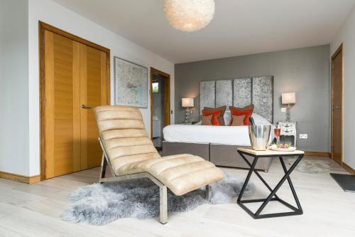 a bedroom with a bed and a chair and a table at The Hideaway Experience in Dundee