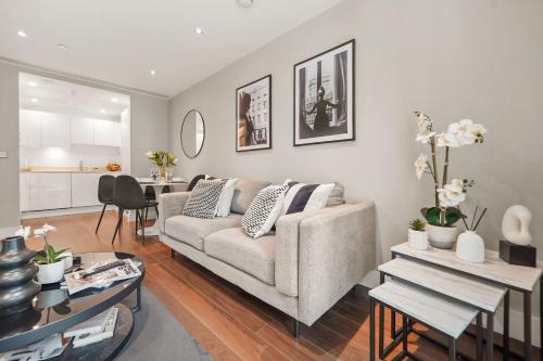 a living room with a couch and a table at Luxury 1 bed flat, minutes from Canary Wharf and South Quay Station in London