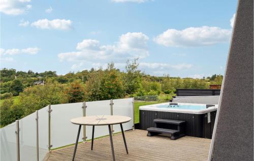 a patio with a hot tub and a table at Beautiful Home In Spttrup With Wifi in Lihme