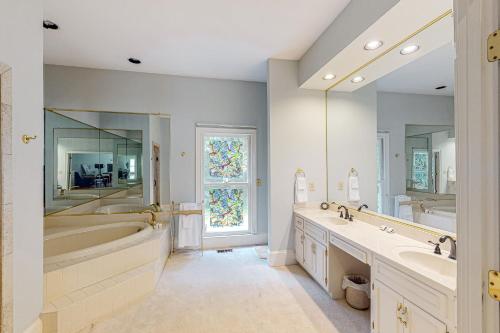 a bathroom with two sinks and a tub and a large mirror at Fresh Getaway in Fayetteville