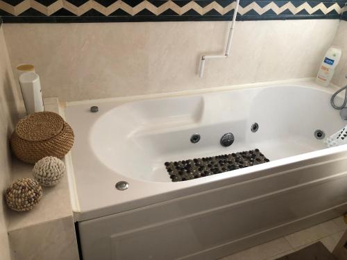 una vasca da bagno bianca seduta in bagno di Miamar House 6 Sesimbra a Sesimbra