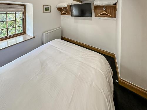 - un lit blanc dans une chambre avec fenêtre dans l'établissement Three Peak Cottage, à Horton in Ribblesdale