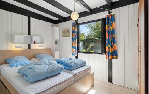 um quarto com uma cama com almofadas azuis em Gorgeous Home In Grlev With Wifi em Gørlev
