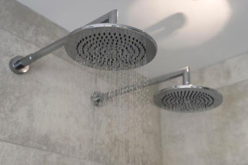 a shower with a shower head with water in it at The Hideaway Experience in Dundee