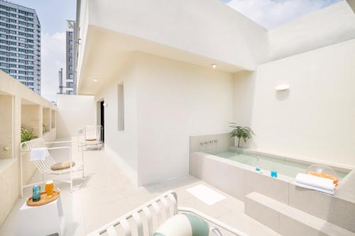 uma casa de banho com piscina no meio de um edifício em Busan H-AVENUE Hotel Seomyeon Station em Busan