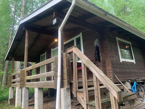 a log cabin with a large porch and a wooden ramp at Rauhallinen mökki luonnon keskellä. in Orivesi