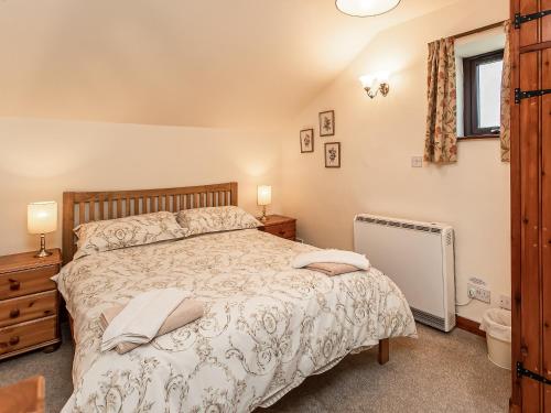 a bedroom with a large bed and a window at Jerusalem Cottage in Longnor