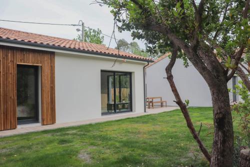 uitzicht op de achtertuin van een huis bij Charmante Maison neuve au Lac d'Hourtin in Hourtin