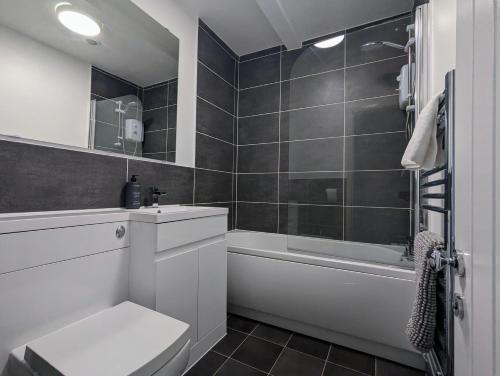 een badkamer met een toilet, een bad en een wastafel bij Conegra Road by Wycombe Apartments in High Wycombe