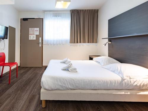 a bedroom with a large bed and a red chair at Vacancéole - Les Chambres de la Baie in Roz-sur-Couesnon