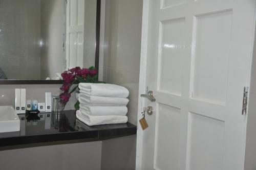 a bathroom with a pile of towels and a mirror at Safa Homestay in Yogyakarta