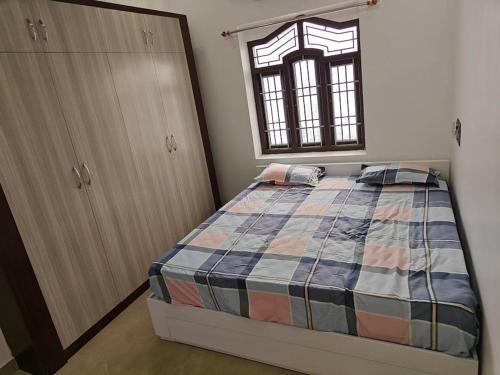a bedroom with a bed and a window at Treva Pent House in Karaikal