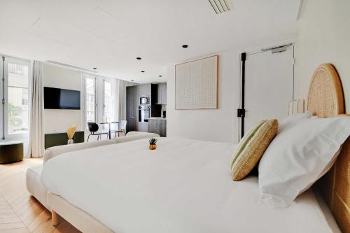 een witte slaapkamer met een groot bed en een woonkamer bij Brand New Modern Studio in Central Paris - 2P - B1 in Parijs