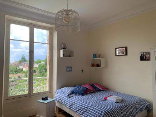 une chambre avec un lit et une grande fenêtre dans l'établissement MAISON 1903 FONTAINEBLEAU, 70kms de PARIS, à Fontainebleau