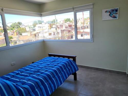 ein Bett in einem Zimmer mit einem großen Fenster in der Unterkunft El Bienestar. in San Salvador de Jujuy