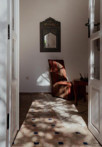 a living room with a chair and a mirror at Villa Maroc Essaouira in Essaouira