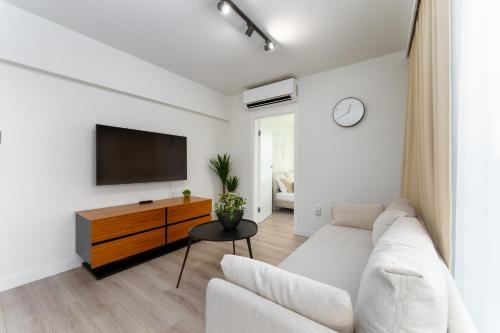 sala de estar con sofá blanco y TV en Sea Waves Apartament Resort & SPA 428B by Renters, en Międzyzdroje