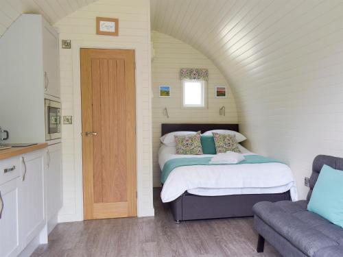 a small bedroom with two beds and a door at Efyrnwy Pod Vip in Llanfyllin