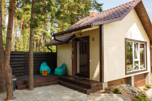 a tiny house with a deck in the woods at Комплекс На Дачі in Vyshpolʼ