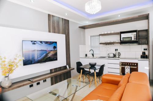 sala de estar con sofá y cocina en The Lofts Luxury Suites en Windhoek