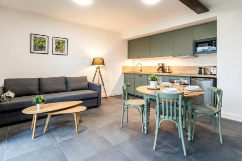 un salon avec un canapé, une table et des chaises dans l'établissement Petit Bretonnerie, à La Haie-Fouassière