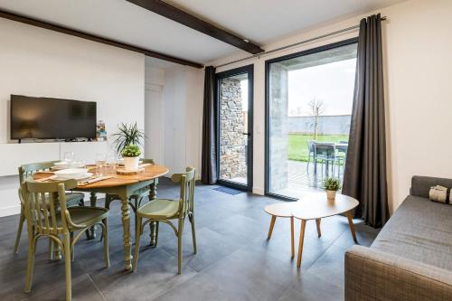 un salon avec une table, des chaises et un canapé dans l'établissement Petit Bretonnerie, à La Haie-Fouassière