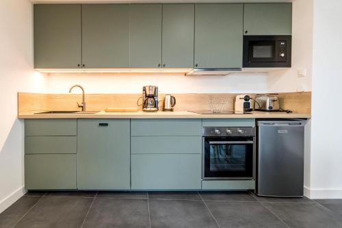 une cuisine avec des armoires bleues et un évier dans l'établissement Petit Bretonnerie, à La Haie-Fouassière