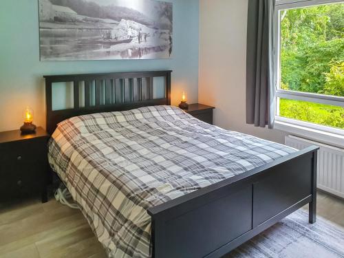 a bedroom with a bed with a plaid blanket at Ferry Cottage in Pitlochry