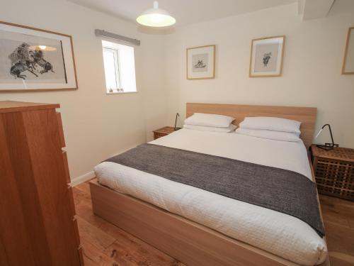 a bedroom with a large bed with white sheets at Plum Hill Apartment in Oswestry