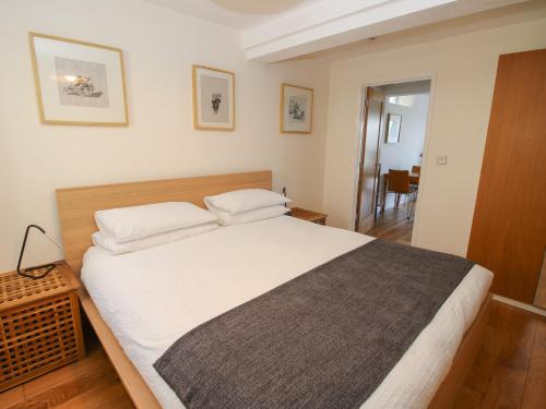 a bedroom with a large bed with white sheets at Plum Hill Apartment in Oswestry