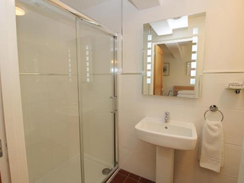 a bathroom with a glass shower and a sink at Plum Hill Apartment in Oswestry